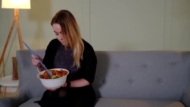 Pareja comer ensalada en el sofá — Vídeo de stock
