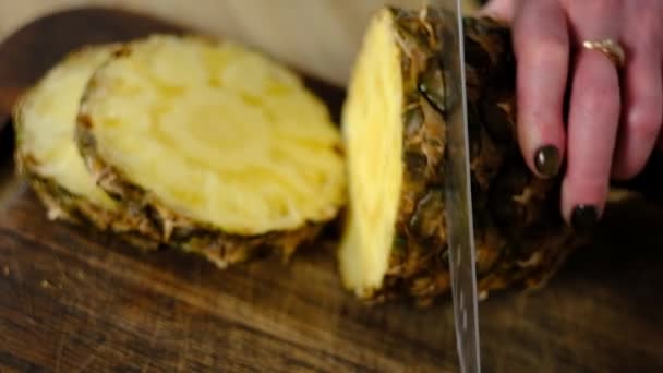 Girl cuts pineapple in the kitchen — Stock Video