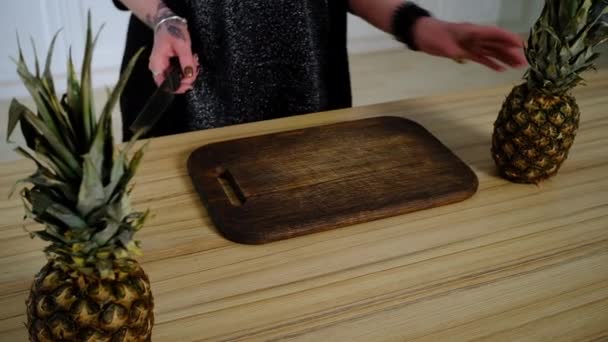 Flicka skär ananas i köket — Stockvideo