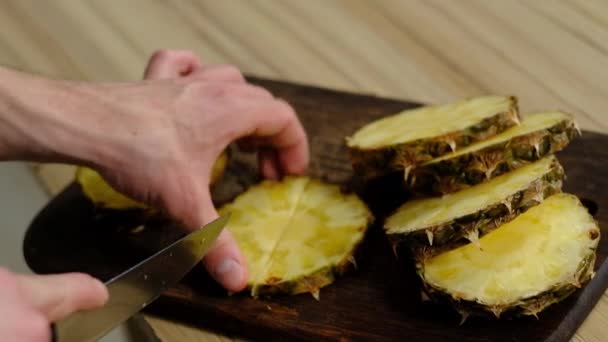 Человек разрезает ананас по кругу — стоковое видео
