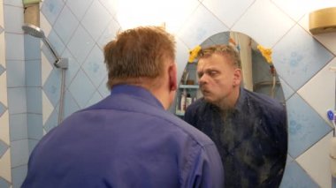Bir adam yüzünü komedilerden temizler.