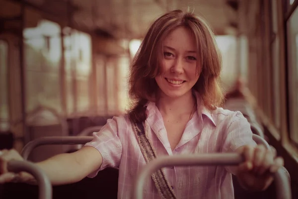 Kız boş bir tramvayda oturuyor.