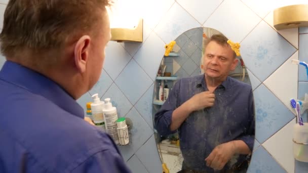 Een man in de badkamer wast — Stockvideo
