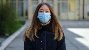 Maskeli genç bir kadın elinde toprağı tutuyor.