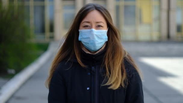 Дівчина в медичній масці і глобусі в руках — стокове відео