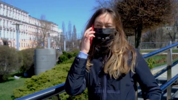 Hablando en un smartphone en la calle durante una epidemia de coronavirus — Vídeo de stock