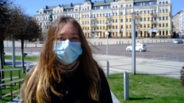 Κορίτσι με ιατρική μάσκα περπατάει στο δρόμο. — Αρχείο Βίντεο