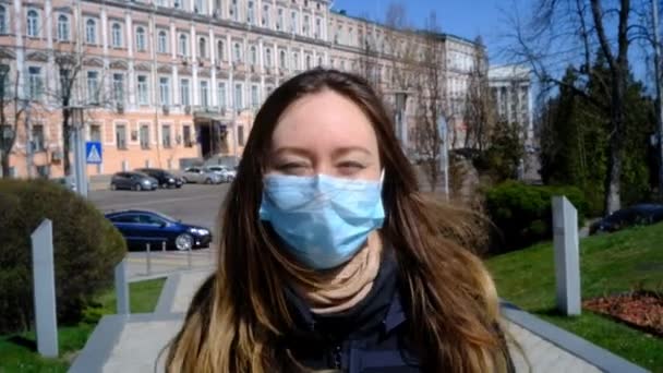 Дівчина в синій масці йде вулицею — стокове відео