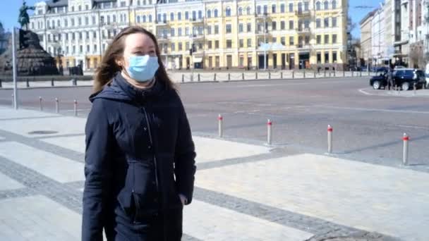 Meisje in een medisch masker loopt over het plein — Stockvideo