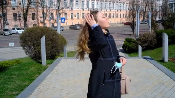 Дівчина одягає маску на вулиці — стокове відео