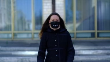 Maskeli bir kız ve bir poster Coronavirus 'a karşı zaferle seviniyor.