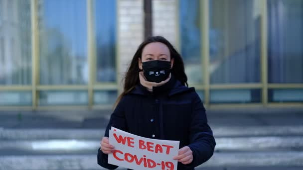 Menina em máscara protetora médica e cartazes sobre o fim da quarentena — Vídeo de Stock