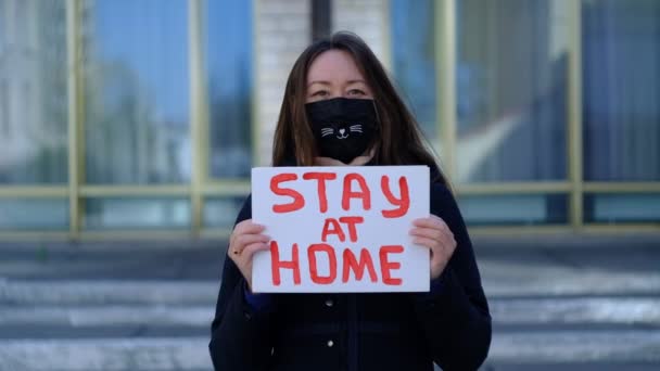 Vermummtes Mädchen mit Rufplakaten in der Hand — Stockvideo