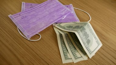 Masada tıbbi maske ve dolar var..