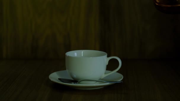 Caffè viene versato in una tazza bianca su un piattino — Video Stock