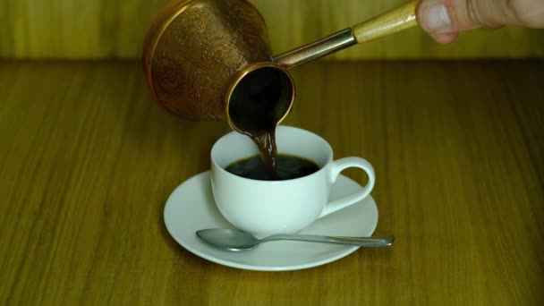 Bakır bir Türk kahvesi küçük beyaz bir fincana dolduruluyor. — Stok video