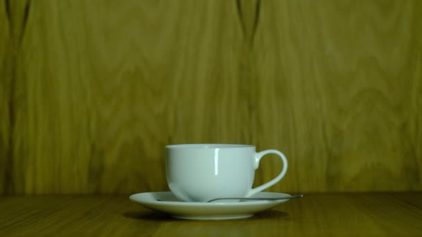 Piccola tazza bianca con caffè su un piattino — Video Stock