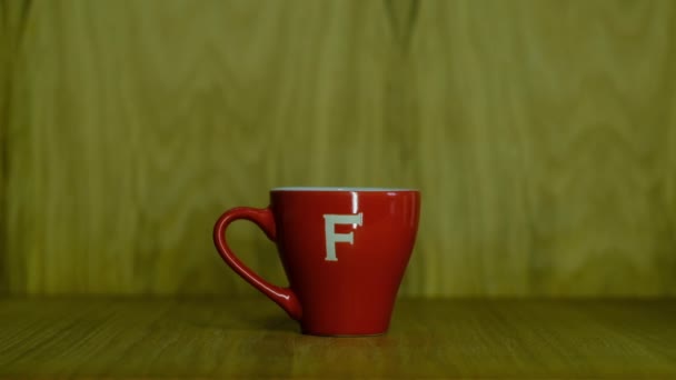 Se vierte el café en una elegante taza roja — Vídeo de stock