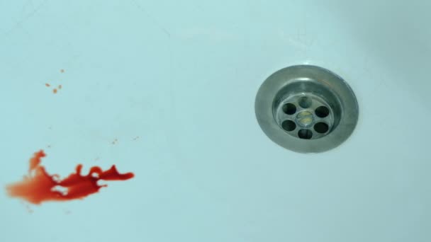 Bloed druppelt en verspreidt zich over een schone wastafel — Stockvideo