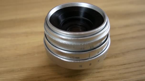 Srebrny obiektyw do kamery 25mm na stole — Wideo stockowe