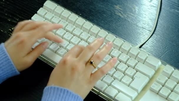 Flickan skriver på ett vitt tangentbord. — Stockvideo