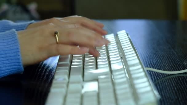 Κορίτσι πληκτρολογεί σε ένα λευκό πληκτρολόγιο. — Αρχείο Βίντεο