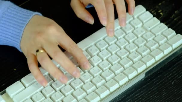 Meisje typt op een wit toetsenbord. — Stockvideo