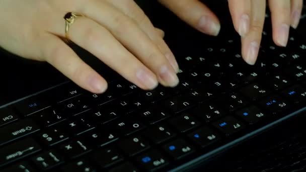 Chica con un anillo en el dedo escribiendo texto en un teclado negro . — Vídeo de stock