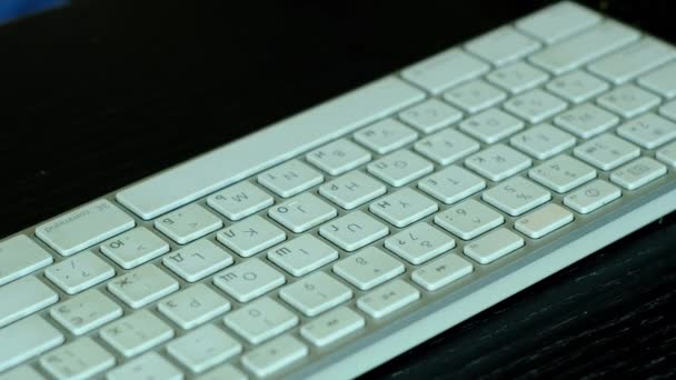 Uma menina é jogado por um pequeno carro branco no teclado do computador . — Vídeo de Stock