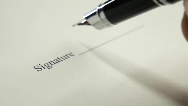 Un homme signe un document avec un stylo à encre .