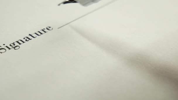 Un homme signe un document avec un stylo à encre .