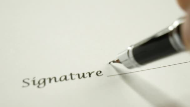 Un homme signe un document avec un stylo à encre .