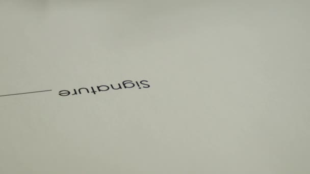 Un homme signe un document avec un stylo à encre .