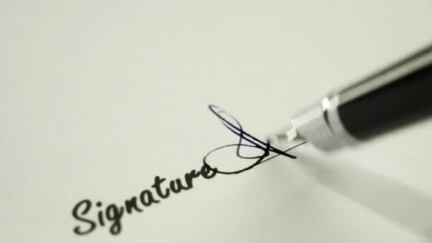 Un homme signe un document avec un stylo à encre .