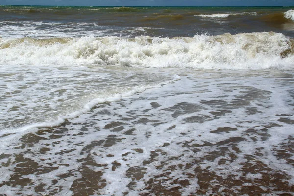 Schiuma di mare nella sabbia dopo una grande onda e surf — Foto Stock