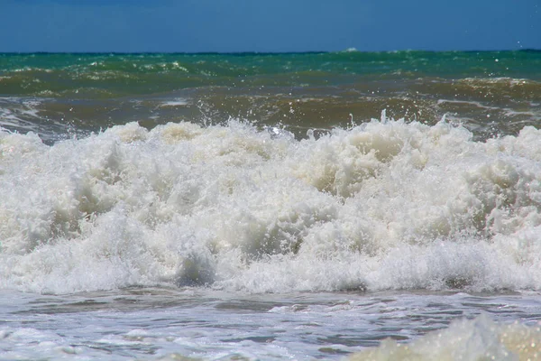 Schiuma di mare nella sabbia dopo una grande onda e surf — Foto Stock