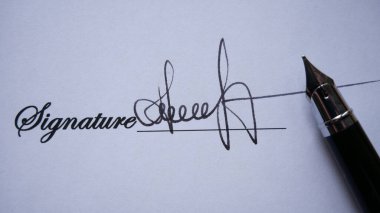 Mürekkep kalemle önemli bir belgede yakışıklı bir adam imzası