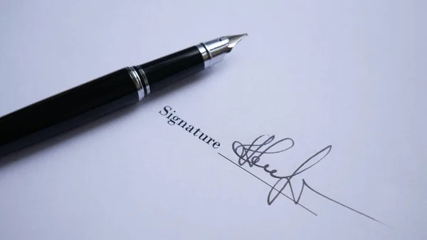 Mürekkep kalemle önemli bir belgede yakışıklı bir adam imzası