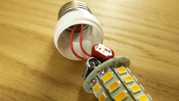 Prise E27 sur la lampe LED. Condensateurs et carte à souder sont visibles . — Video