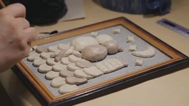 Cilalama işleminden önce kadın sanatçı el yapımı tabloyu temizliyor