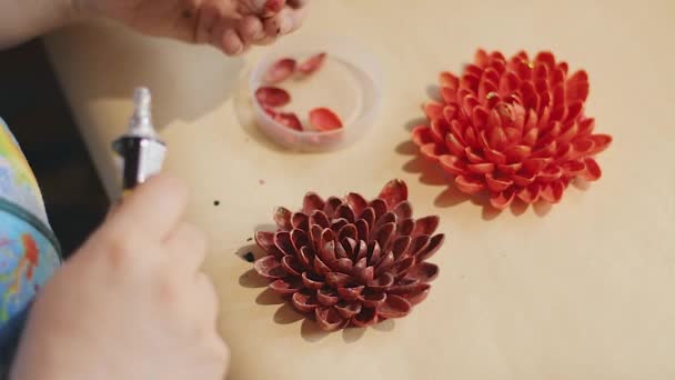 Femme artiste fait un design de fleurs décoratives avec des coquilles de noix peintes — Video