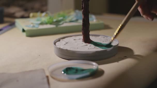 A női művész festi a kézzel készített drótfákat a lakkozás előtt. — Stock videók