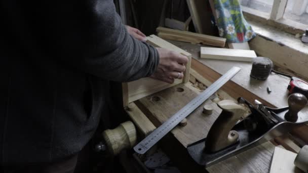 Плотник-мужчина строит деревянную доску с самолетом для сосновой полки — стоковое видео