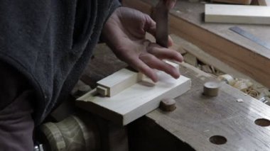 Erkek marangoz keskiyle çam ağacı rafı için tahta kesiyor.