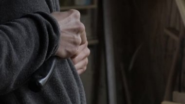 Erkek marangoz bir keski ile çam rafı için ahşap tahtalar oluşturuyor.