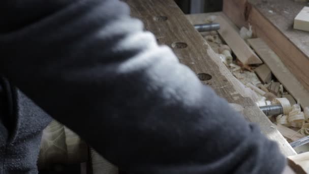 Male carpenter measuring wooden plank for the pine shelf with curved and straight ruler and marking it with a pencil — Stock Video