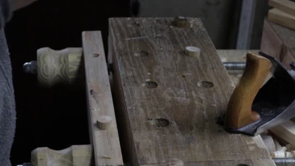 Плотник-мужчина строит деревянную доску с самолетом для сосновой полки и проверяет ее — стоковое видео