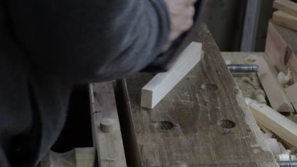 Плотник-мужчина строит деревянную доску с самолетом для сосновой полки и проверяет, подходит ли она для строительства — стоковое видео
