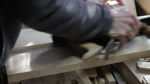 Mężczyzna stolarz struganie z drewnianej krawędzi deski z jack-plane dla sosny półki na jig dla doskonały kąt 90 stopni — Wideo stockowe