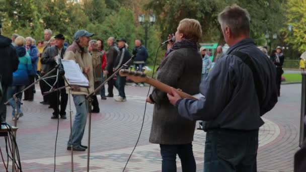 Chernihiv, Ukrayna 22 numara 2019. Şarkıcı ve bas gitarist parktaki emekli dans partisinde sahne alıyorlar. — Stok video